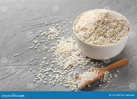 Cuenco Y Cucharada Con Arroz Corto Del Grano En Fondo Ligero Foto De