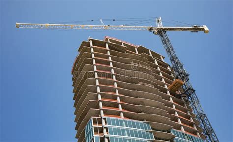 A Crane Rissing Above A New High Rise Building Under Construction