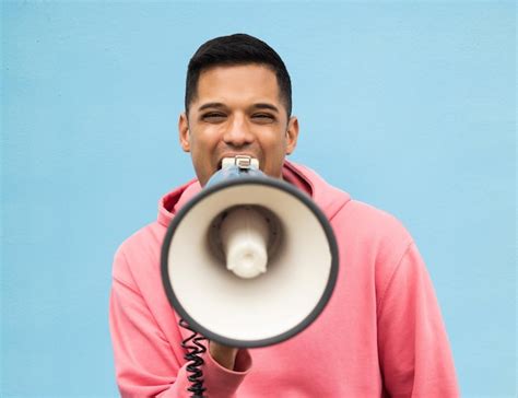 Protesto de retrato e megafone um homem no estúdio em um fundo azul