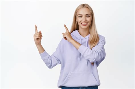 Belle Femme Blonde Pointant Du Doigt Le Coin Sup Rieur Gauche Souriant Amical Montrant Une