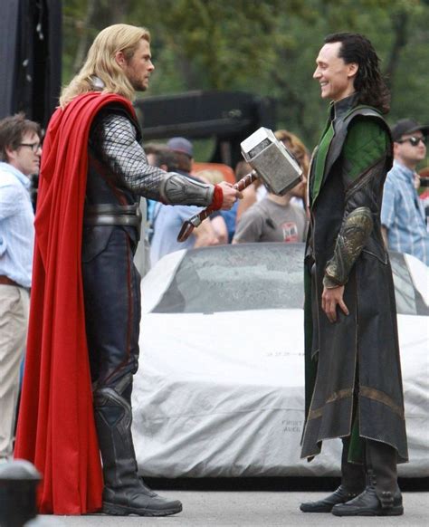 Two Men Dressed As Thor And Loki In Front Of A Car With People Standing