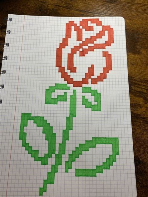 An Image Of A Flower Made Out Of Graph Paper On A Wooden Table With Pen