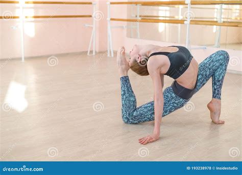 Very Flexible Caucasian Woman Doing Stretching Exercises In Dance Class