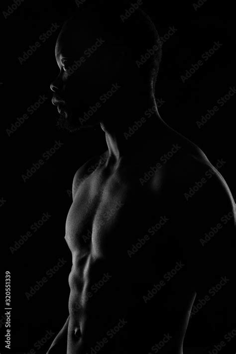 Black And White Portrait Of A Handsome Black Man With Naked Sports Torso On Dark Background