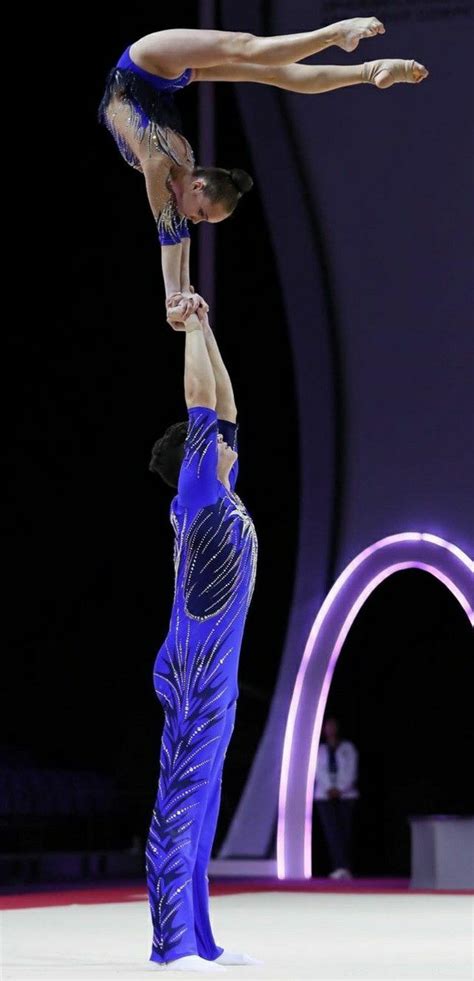 Two People Doing Acrobatic Tricks On The Floor