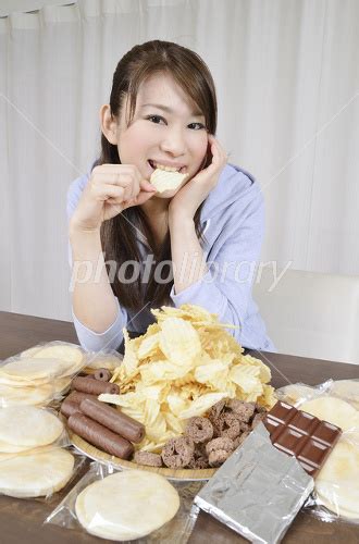 山盛りのスナック菓子を食べる女性 写真素材 1974721 フォトライブラリー Photolibrary