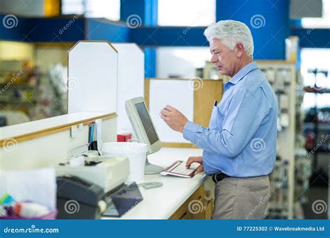 Pharmacist Making Prescription Record Through Computer Stock Photo