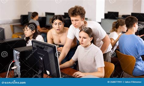 Focused Teenagers Helping To The Female Classmate While She Is Learning