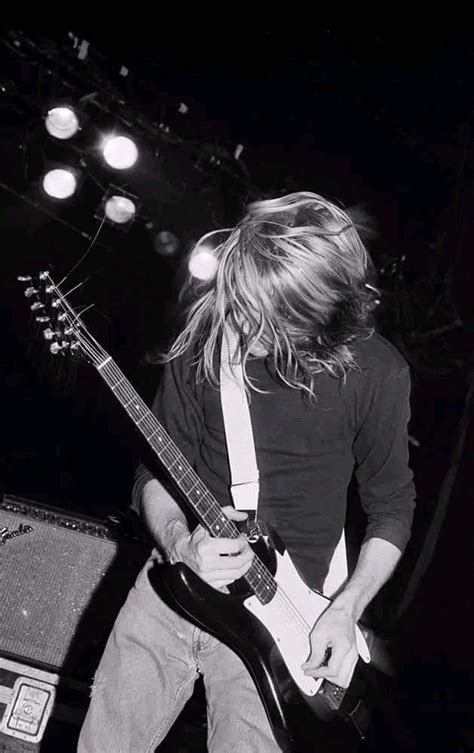 A Man With Long Hair Playing An Electric Guitar