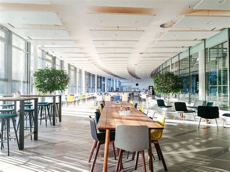 An Empty Dining Room With Tables And Chairs