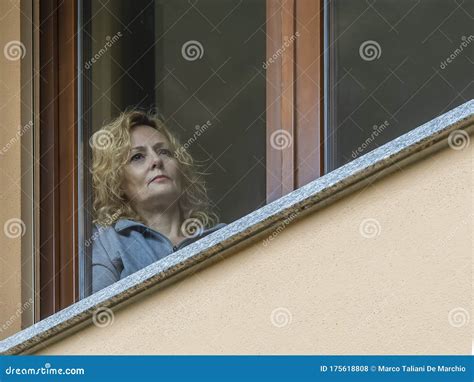 An Italian Blonde Woman Forced To Stay Indoors Because Of Coronavirus Covid 19 Looks At The