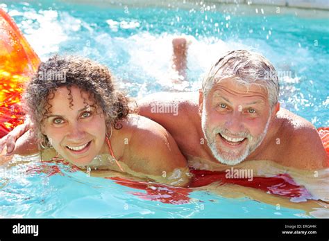 Mature Couple Relaxing On Airbed In Swimming Pool Stock Photo Alamy