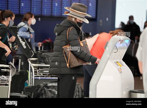 Passenger uses the self-service kiosk to check in at the counter for ...