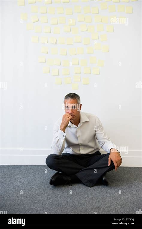 Businessman Sitting Behind Wall Covered In Sticky Notes Stock Photo Alamy