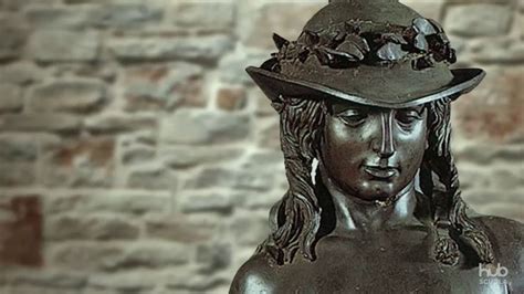 A Bronze Statue With A Hat On It S Head And Brick Wall In The Background