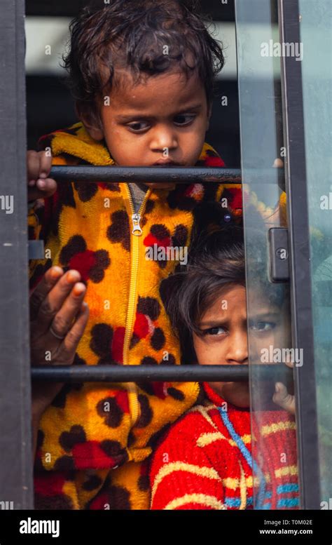 AGRA, INDIA - NOVEMBER 15, 2012: Indian poor dirty kids ride the train and look out the window ...