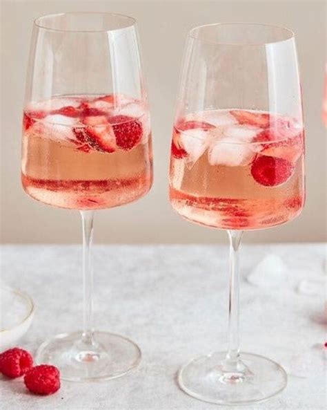 Two Wine Glasses Filled With Raspberries And Ice