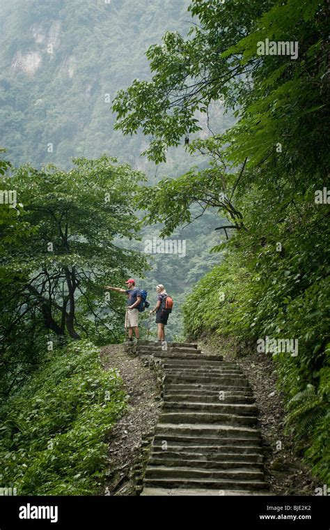 Two Western Trekkers Climbing Towards The Peak Of Emei Shan A Holy