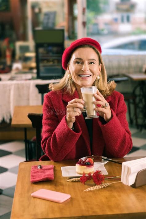 Beaming Blonde Haired Woman Wearing Red Coat And Beret Drinking Coffee Stock Photo Image Of