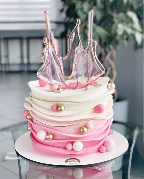 A Pink And White Cake On A Glass Table