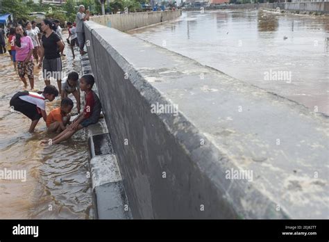 Residents Wade Through A Waterlogged Area In Kampung Melayu East