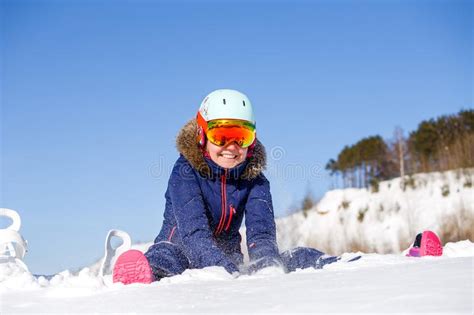 Foto Del Atleta De Sexo Femenino En El Casco Que Se Sienta En La Nieve