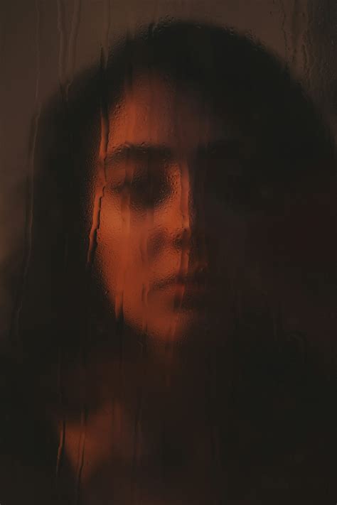 Woman's face seen through rain-streaked glass photo – Free Dark Image
