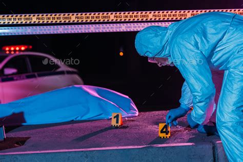 Middle Aged Male Criminologist In Protective Suit And Latex Gloves