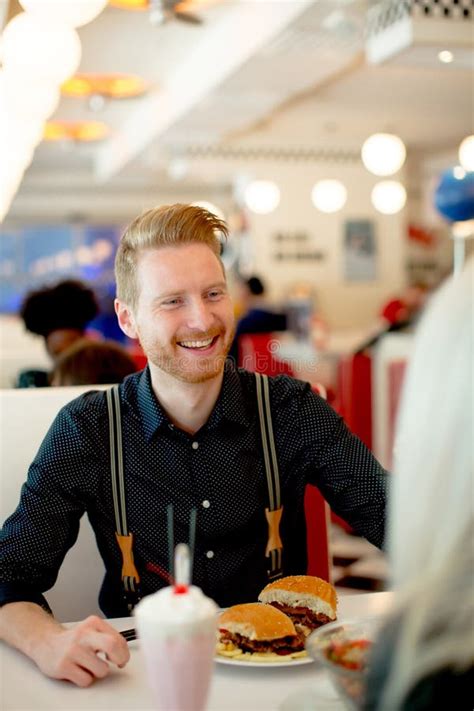 Young Man Eating Cheeseburger In Diner Stock Photo Image Of Meat