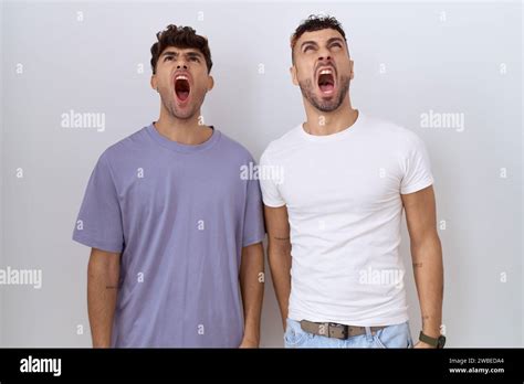 Homosexual Gay Couple Standing Over White Background Angry And Mad Screaming Frustrated And