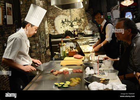 A Japanese Teppanyaki Chef Grilling Kobe Beef Steaks In A Traditional