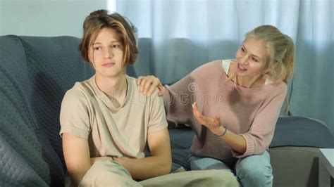 Upset Teenager Sitting On Sofa At Home And Looking Away After Quarrel