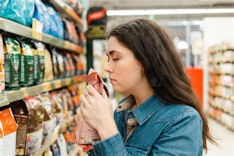 Winkelen In De Supermarkt Een Jonge Brunette Vrouw Kiest Een Product Door Het Geur Door De