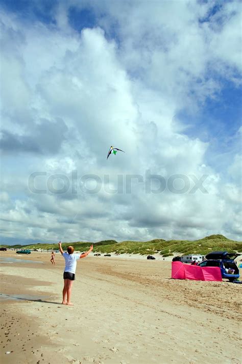 En ung dreng leger med en drage på stranden Stock foto Colourbox