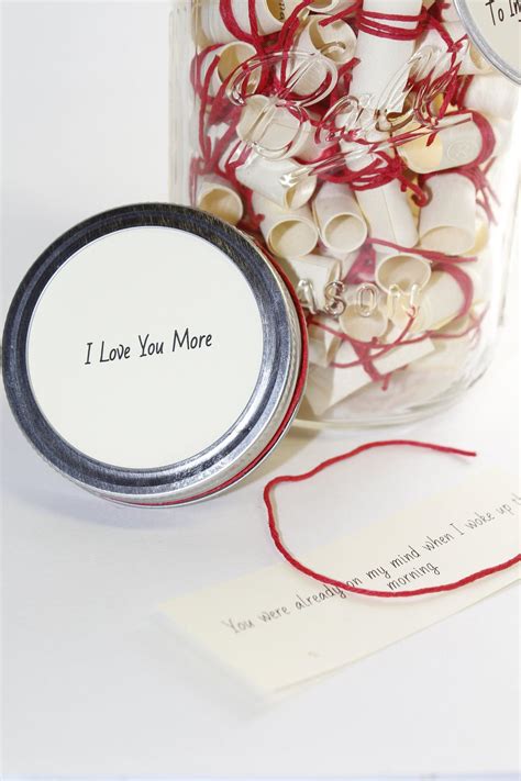 A Jar Filled With Lots Of White And Red Hearts Next To A Tag That Says I Love You More