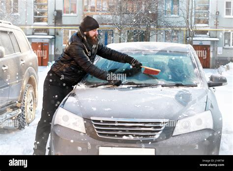 Man Cleans Snow From The Glass At The Car Stock Photo Alamy