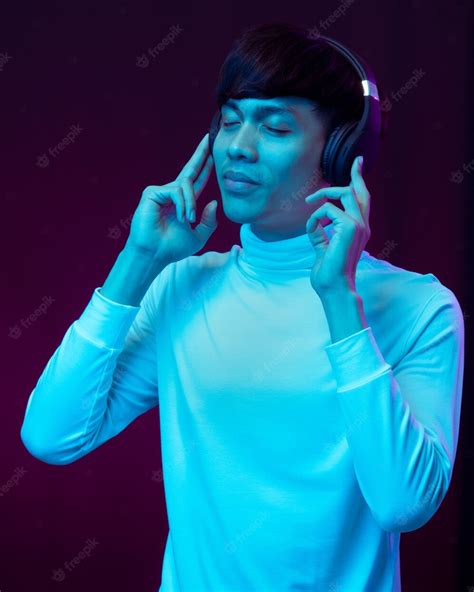 Premium Photo Young Asian Man Listening Music With Headphone In Neon