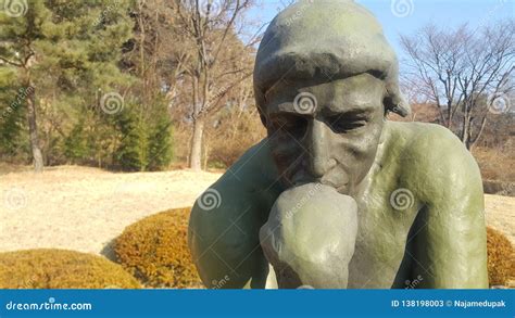 Green Statue Of Thinker Auguste Rodin Setting Naked On A Rock