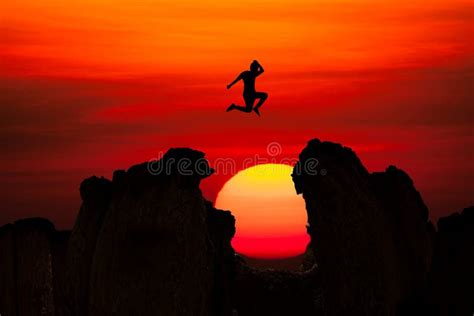 Silhueta De Homem Saltando Sobre A Montanha Sobre O Fundo Do Sol Da