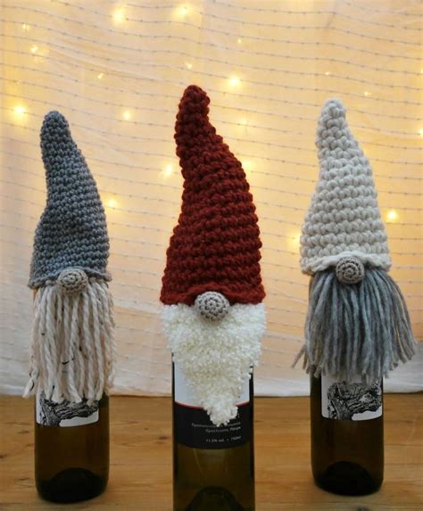 Three Crocheted Wine Bottles With Gnome Hats On Them