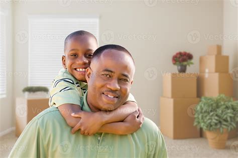 African American Father And Son In Room With Packed Moving Boxes