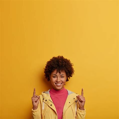 Free Photo Vertical Shot Of Happy Smiling Dark Skinned Woman Points