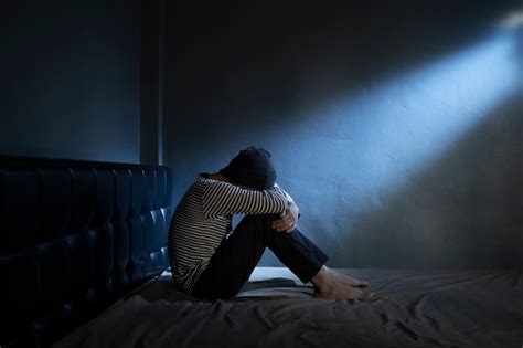 Homme Triste Sur Le Lit Dans La Pièce Sombre Photo Premium