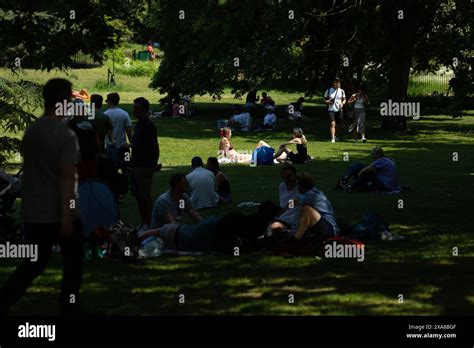 People Enjoy A Spell Of Hot Weather As Some Sunbathe And Others Avoid The Direct Sunshine In