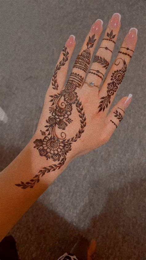 A Woman S Hand With Henna Tattoos On It