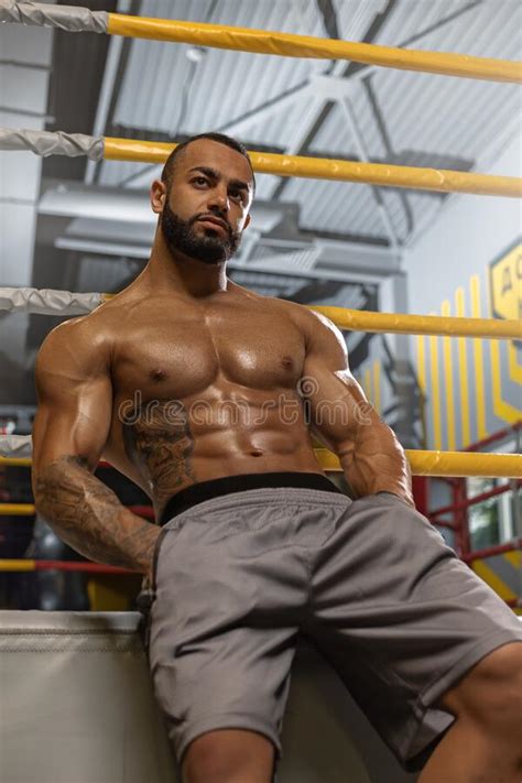 A Strong Man With A Naked Torso And 6 Pack Abs Sits Near A Boxing Ring