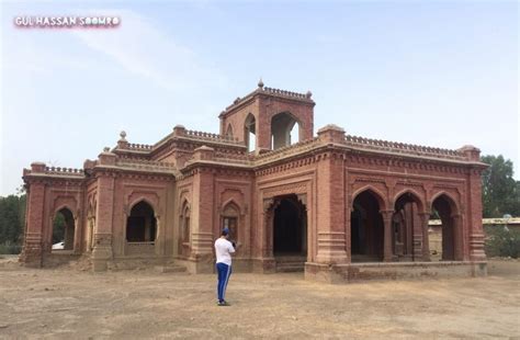 A Man Standing In Front Of An Old Brick Building With Arches And