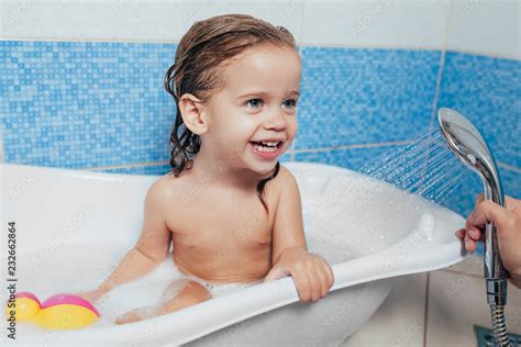 Beautiful Little Girl Taking A Bath At Home A Cute Baby Is Sitting In