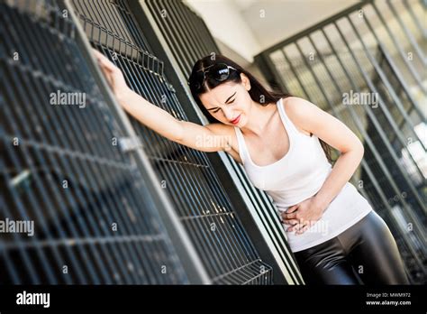 Abdominal Pain In A Woman A Girl Wearing A White T Shirt Is Holding