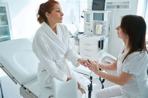 Female Doctor Holding Hand Of Her Patient Sitting On Gynecologist Chair